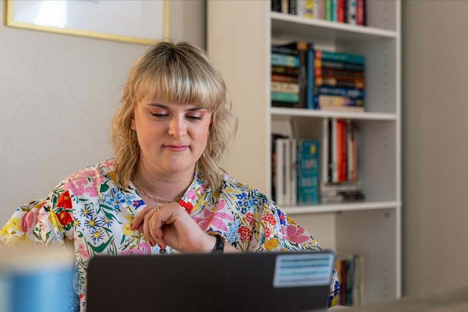 Photo of a Betenbough Homes homeowner working at her computer in a home office.