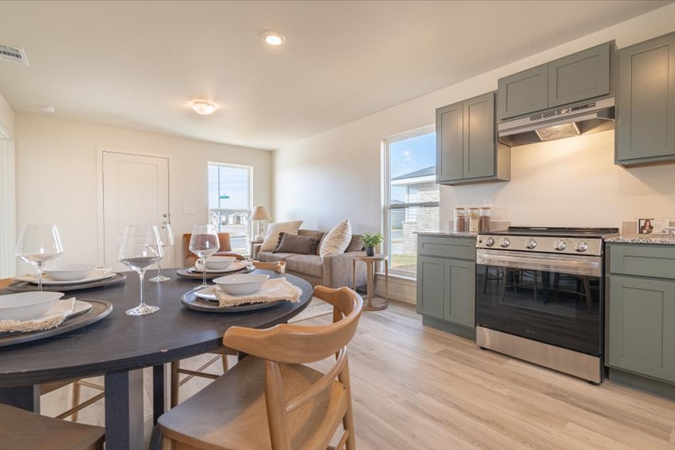 Photo of the furnished kitchen, dining, and living areas of an Origin home.