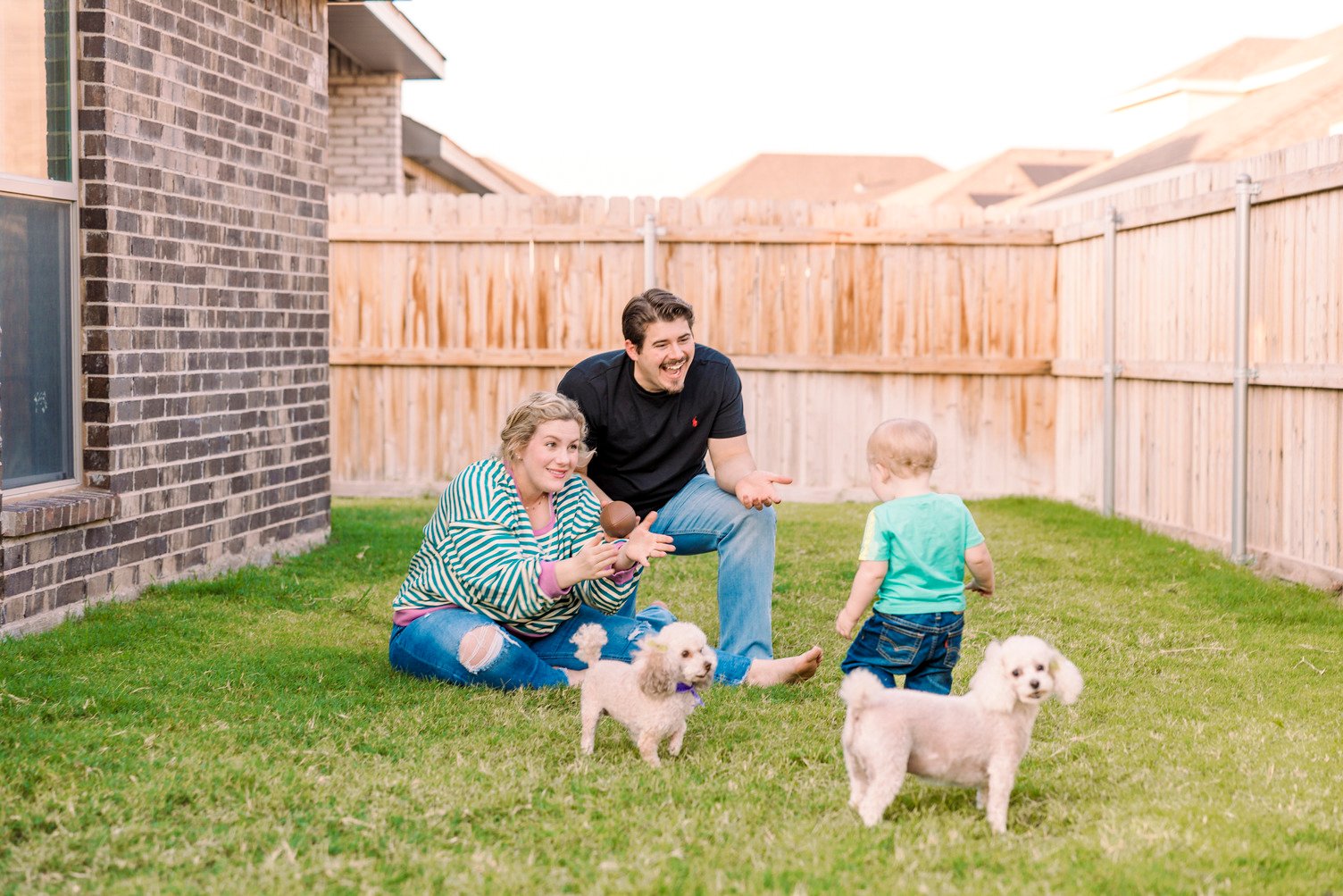 Happy family playing with their dogs in their backyard