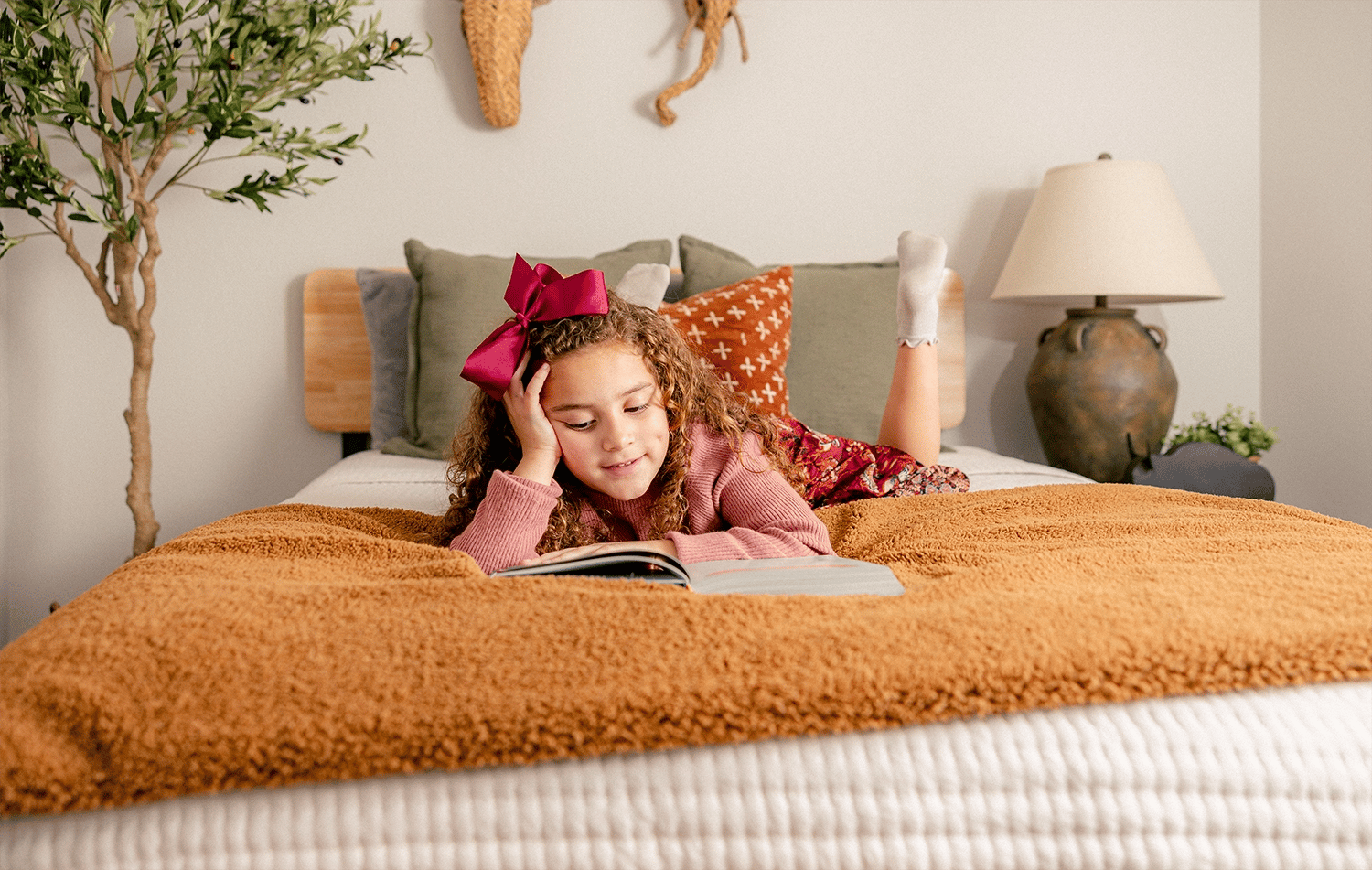 Girl reading in bed at her Betenbough home