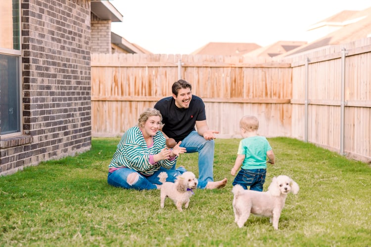 Happy family playing with their dogs in their backyard