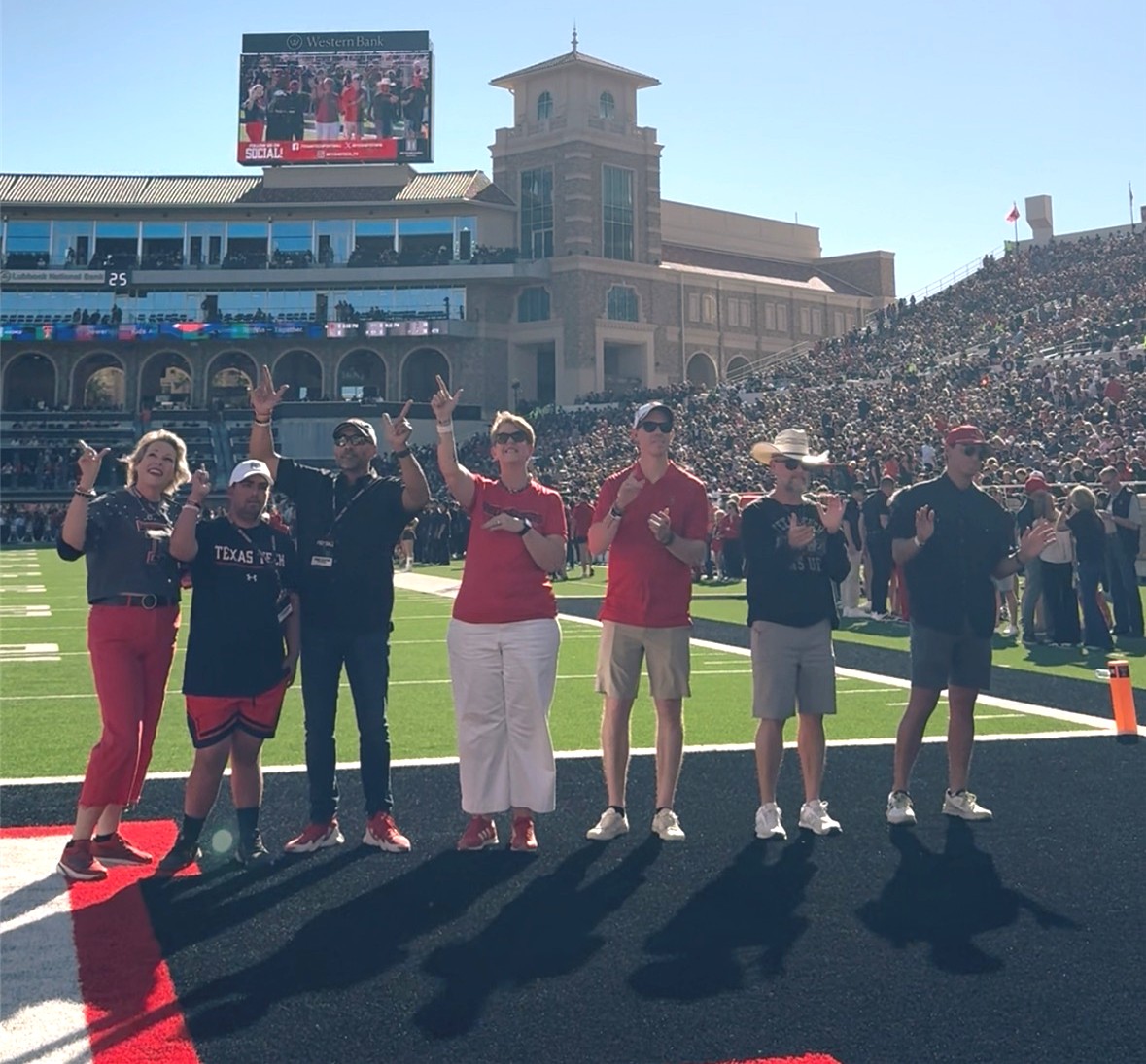 Photo of Betenbough Homes team members on the field with Austin Ramford, the official Team IMPACT recipient for 2025.