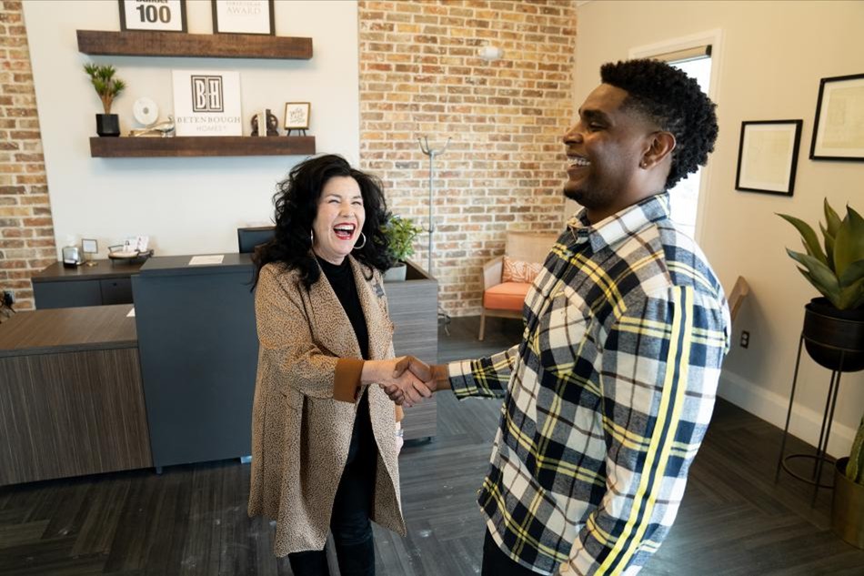Celebrating Comp Photo of a homeowner and Betenbough Homes team member shaking hands in a New Home Center.