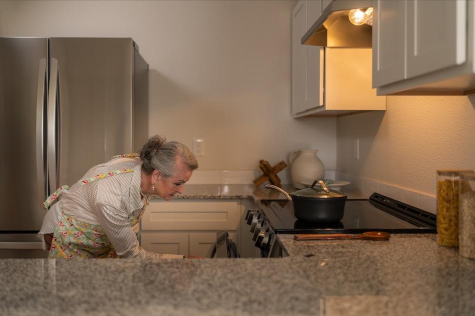 Photo of a woman baking in her Origins home by Betenbough Homes, West Texas' #1 home builder.