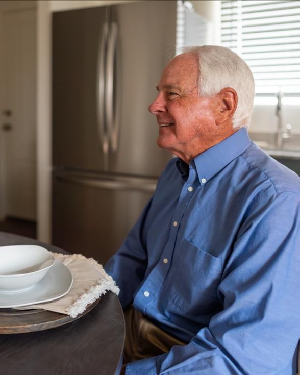 Photo of a man sitting at the dining table in his downsized home by Betenbough Homes, West Texas' #1 homebuilder.