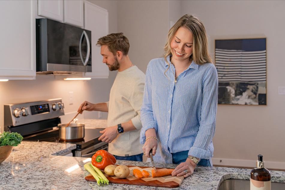 Groceries Comp Photo of a couple preparing a meal in the kitchen of their new Betenbough home.