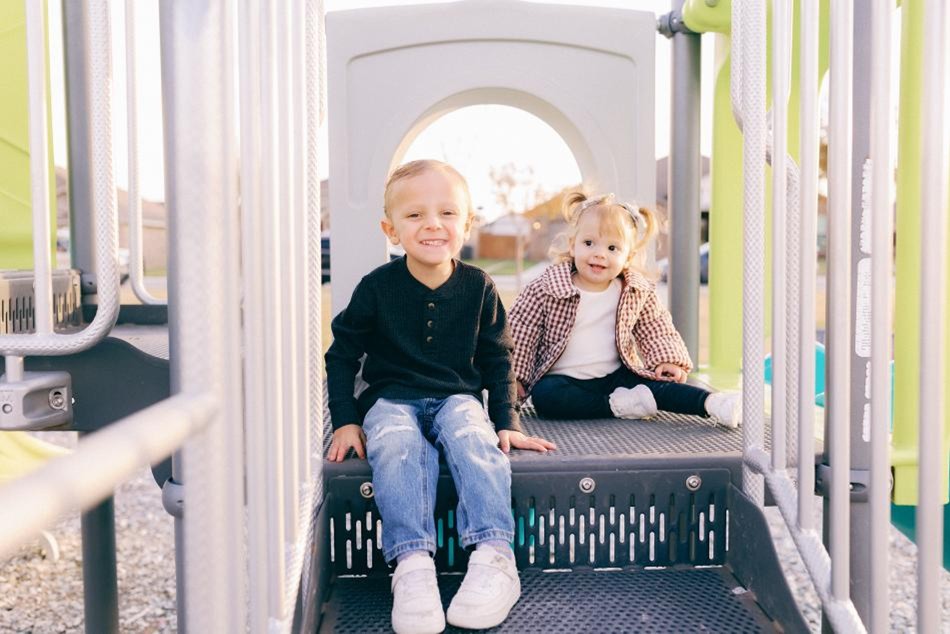Home Comp Photo of a brother and sister playing on the playground of their Betenbough Homes community in Midland, Texas.