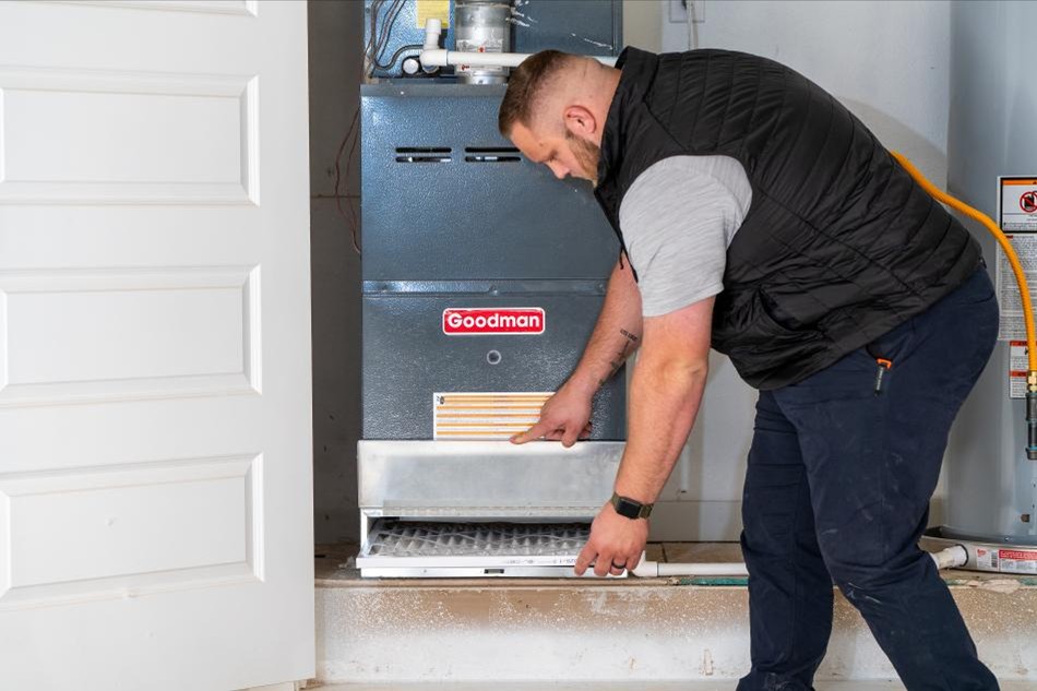 A Betenbough Homes warranty technician teachers a first time home buyer how to replace the air filter on their HVAC system.