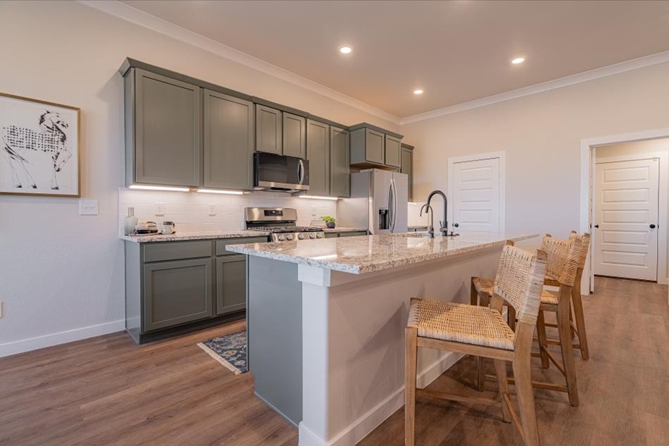 Photo of the kitchen and bar with seating in Betenbough Homes' 2025 Amarillo Parade Home.