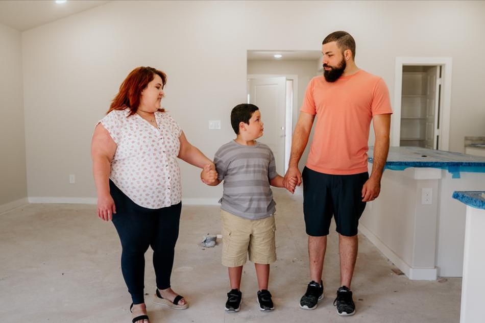 Photo of a family walking through their Betenbough home under construction.