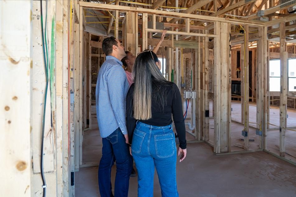 Home buyers on a frame tour, considering the added space they'll enjoy in their new home.