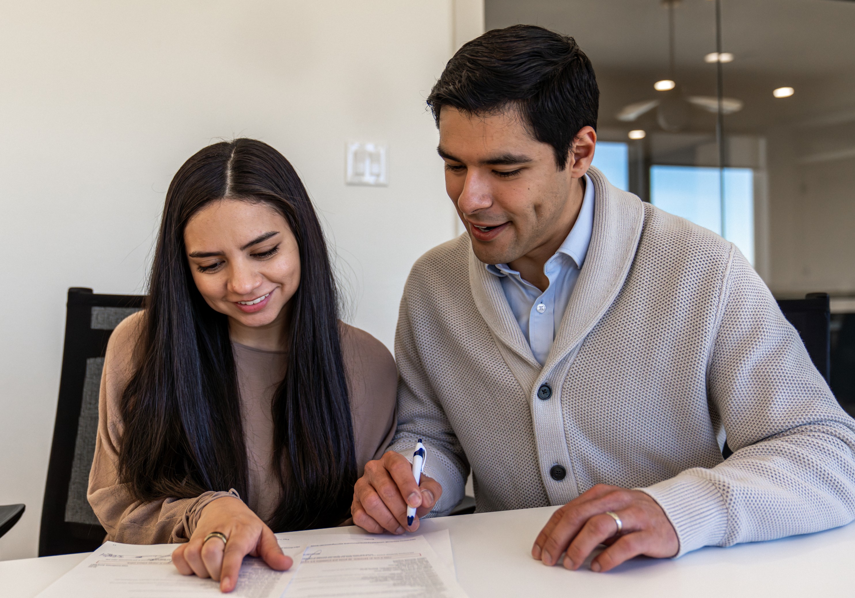 A couple reviews documents in preparation to purchase a new home from Betenbough Homes.
