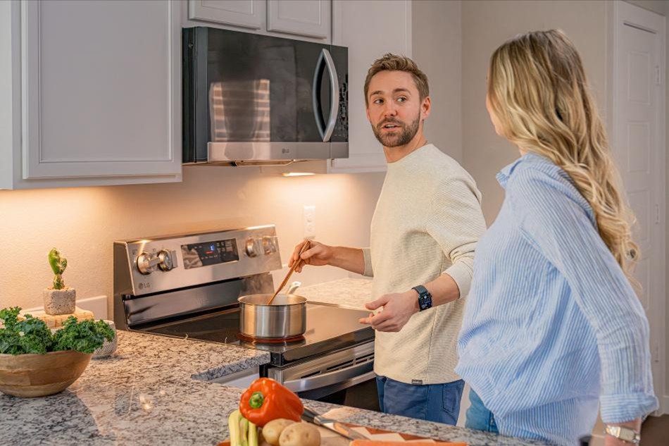 A couple is cooking dinner together in the kitchen of their new Betenbough home.