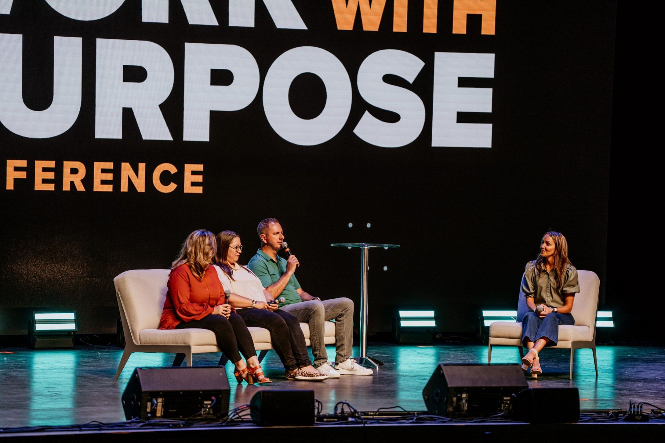 Photo of panelists speaking onstage at the Work with Purpose Conference.