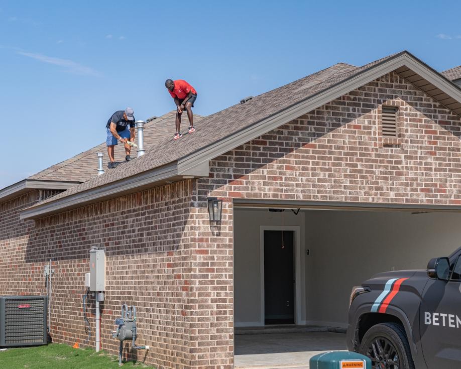 Photo of the Betenbough Homes warranty team inspecting a new home's roof.
