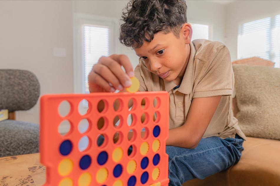 Security Comp Photo of a child playing a game in a Betenbough home.