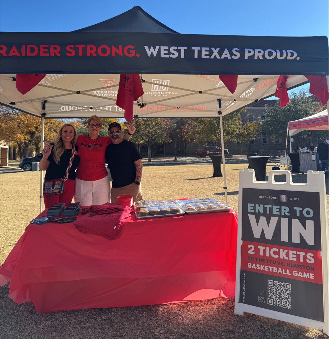 Photo of Betenbough Homes team members tailgating at Raider Alley, giving away 2 tickets to a TTU basketball game, rowdy rags, and pastries from Ninety-Two Bakery and Cafe.