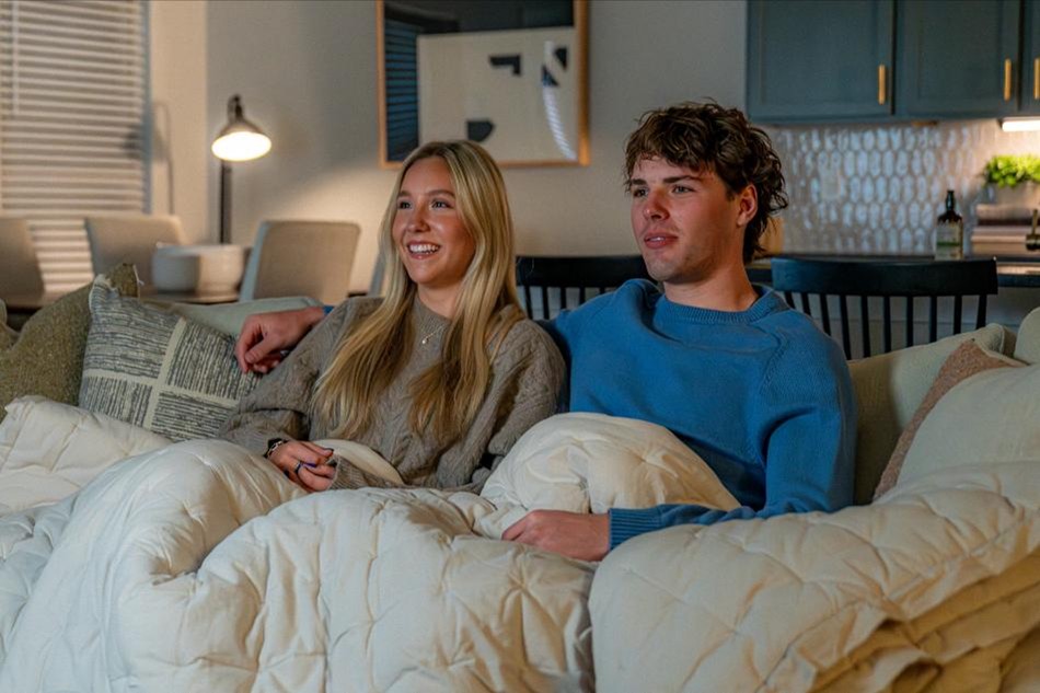 Photo of a couple enjoying movie night in their Betenbough home.