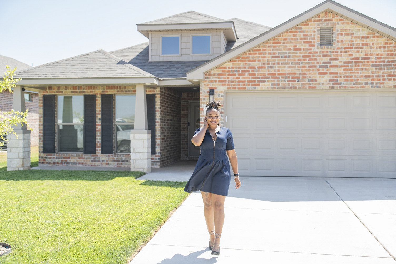 Young woman standing in front of her new West Texas home by Betenbough Homes