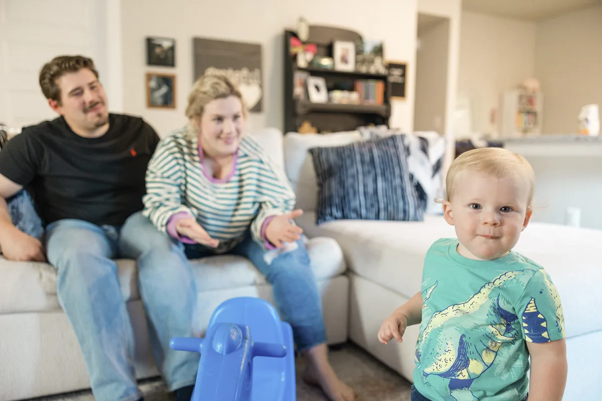 Parents playing with their baby in their Betenbough home living room